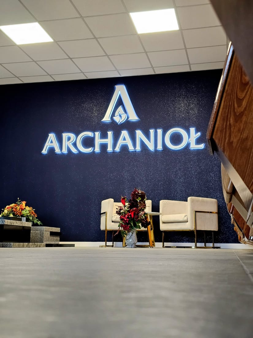 Wnętrze Archanioła — ściana z podświetlonym logo i miejsce do rozmowy